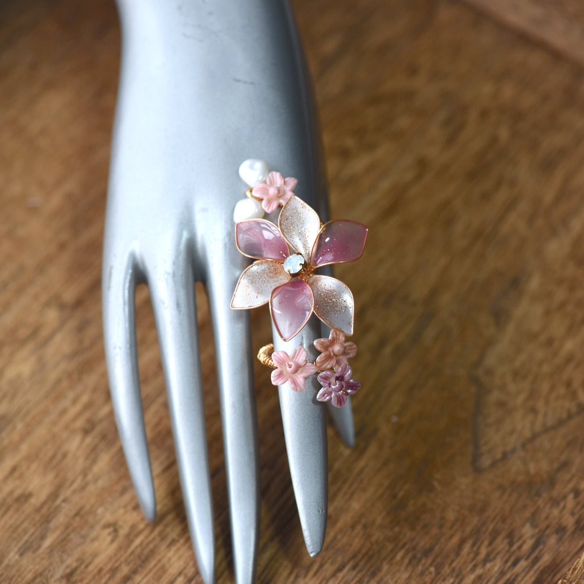 Madeline pink white and lavender resin floral adjustable ring worn on hand
