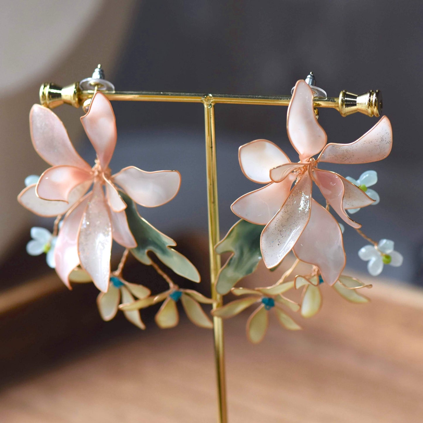 Margot handcrafted blush pink white shimmer resin floral earrings ivory cream cascading petals teal crystal detail
