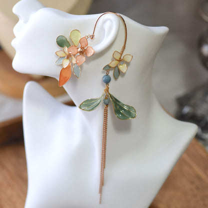 Mehr pastel resin floral ear cuff with rose gold chain tassels shown worn on a white ear display
