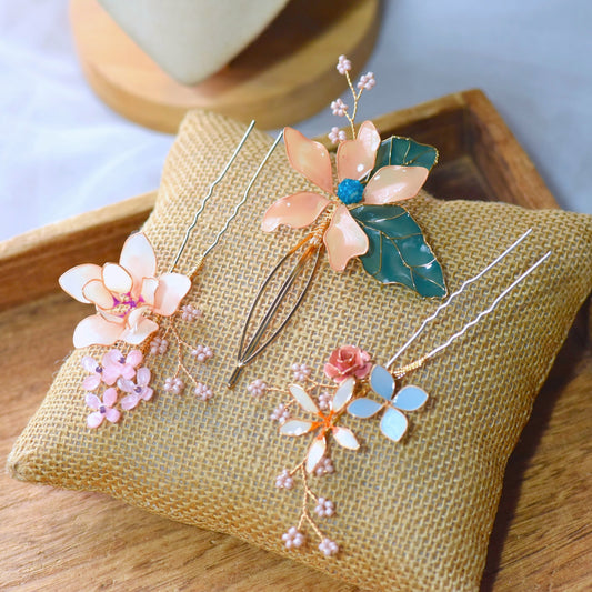 Micaela blush peach pastel blue and ivory resin floral hair pins on an embroidered cushion

