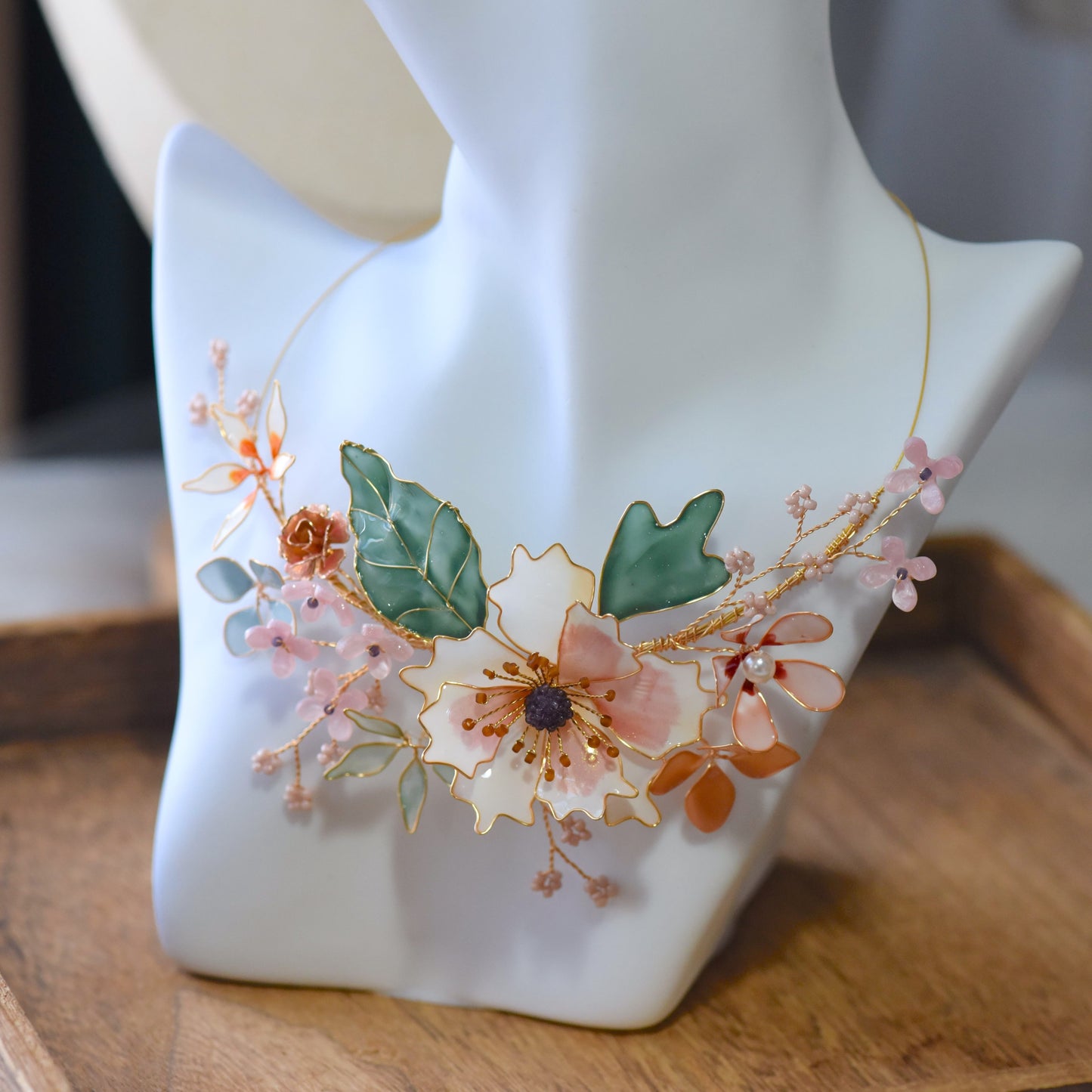 Micaela blush pink peach and green resin floral statement necklace on a white bust
