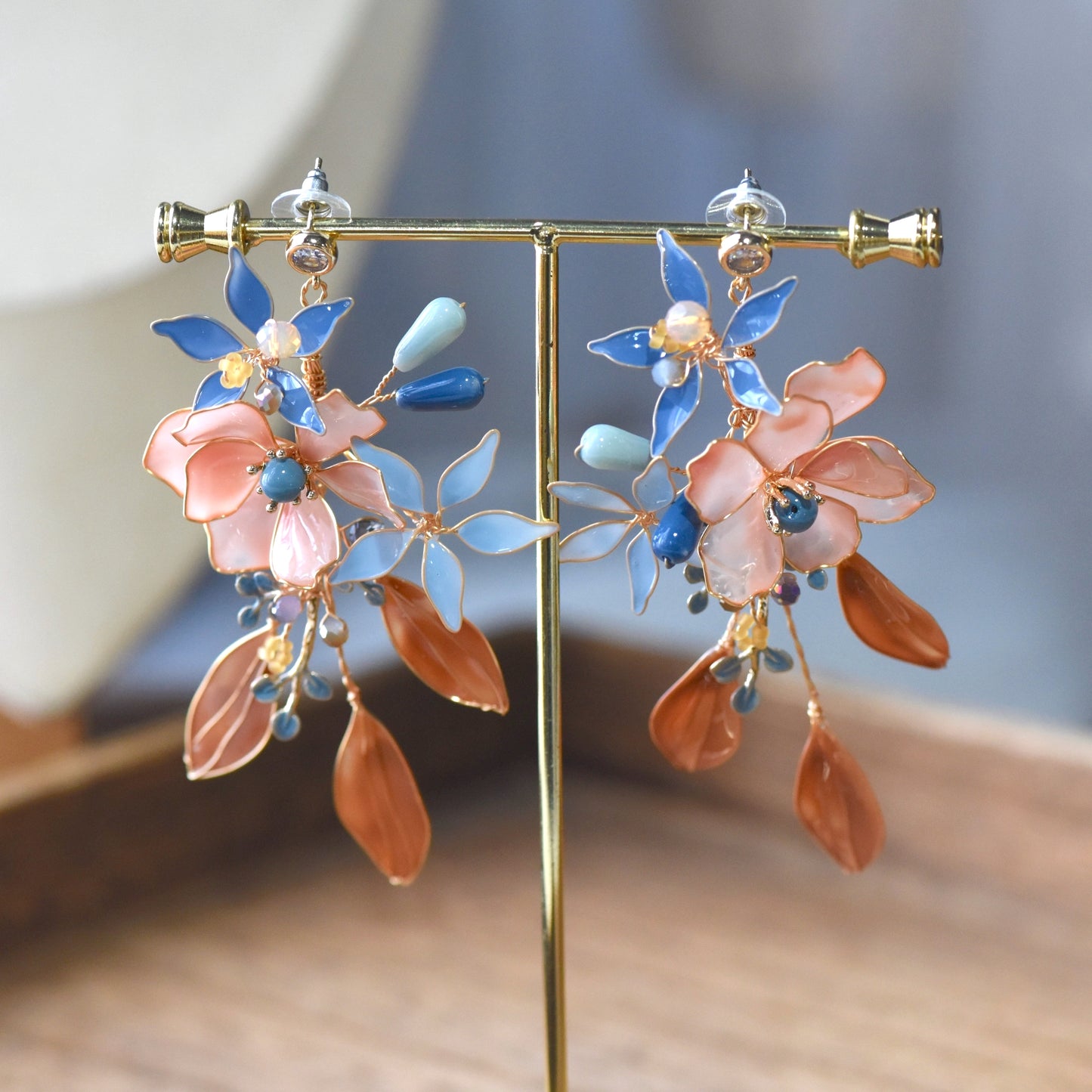 Pair of Nicola floral resin earrings showcasing layered petals, pastel foliage and elegant gold wirework