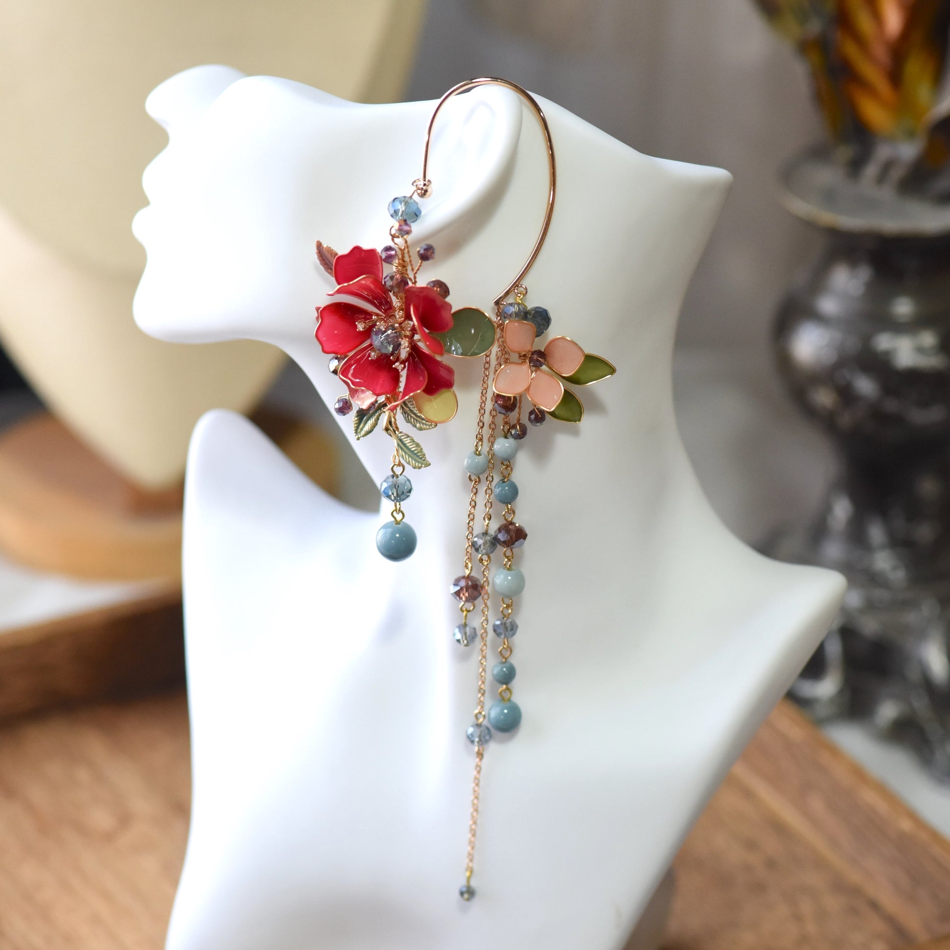 Front view of Raphael floral ear cuff showcasing layered red resin flowers, blush accents and cascading bead chains