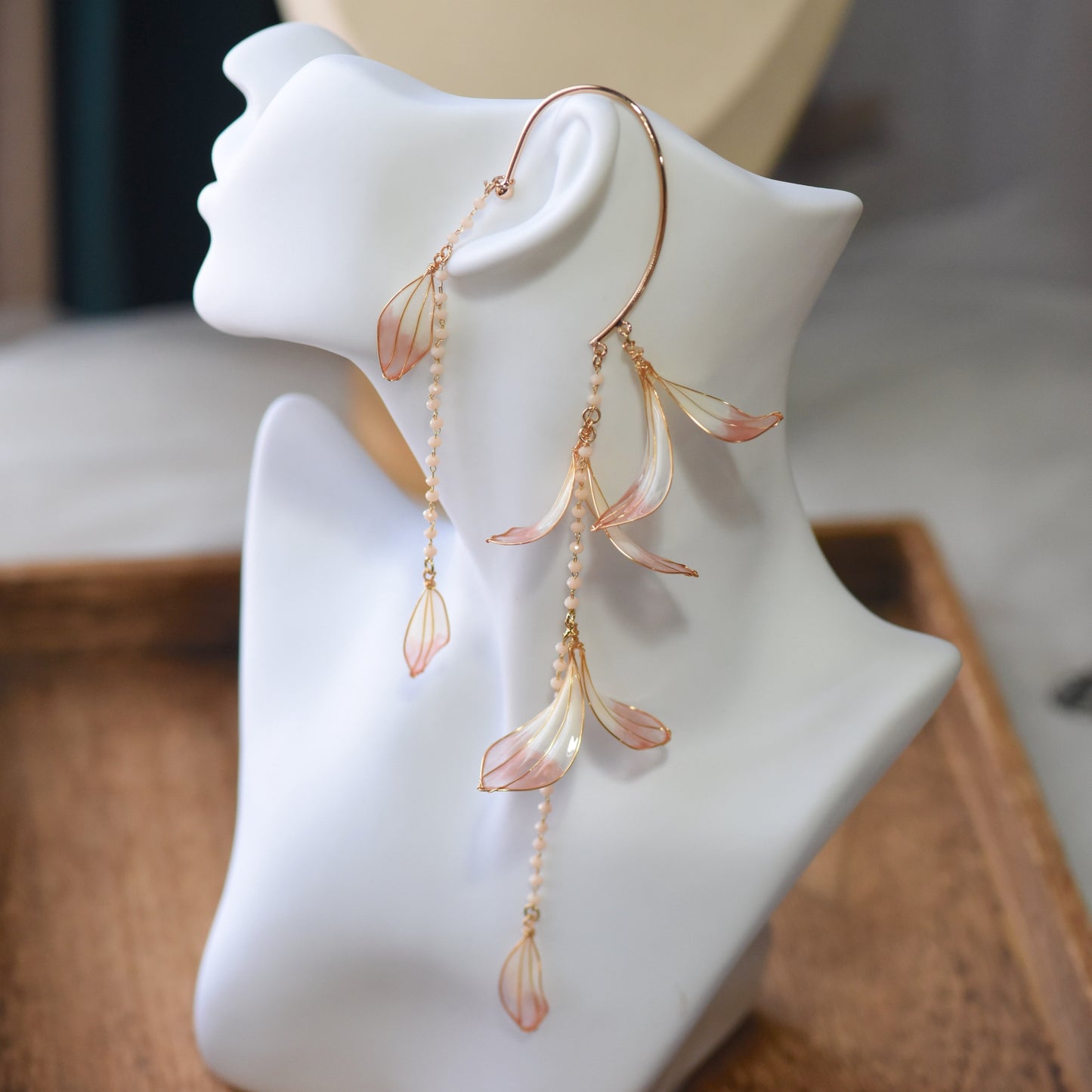 Side view of Raziel floral resin ear cuff showcasing cascading petal drops, pearl accents and delicate gold wirework