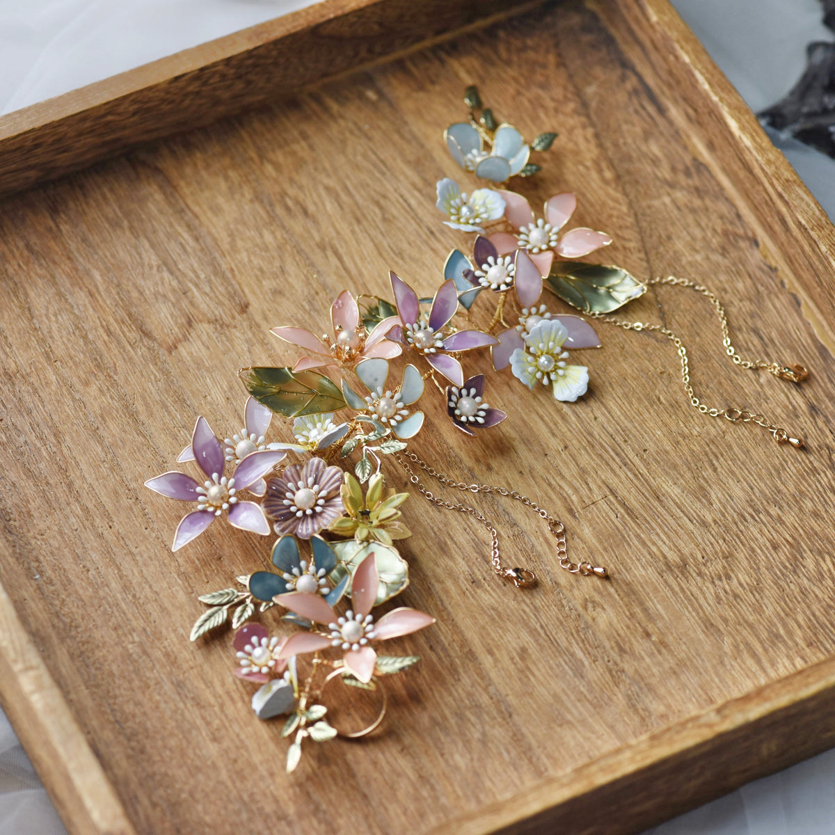 Sabrina multicolour resin floral hand harness on a wooden tray
