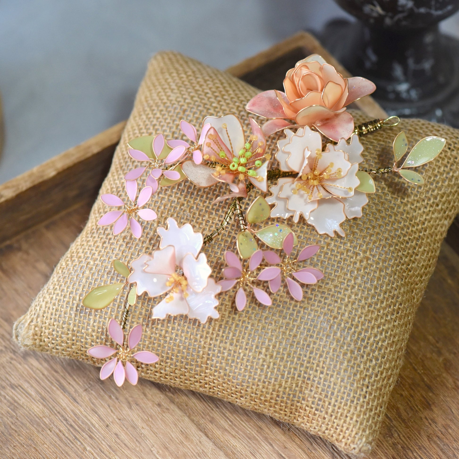 Close-up view of Sadie handcrafted floral hair accessory showcasing pastel resin flowers, foliage and delicate gold wirework