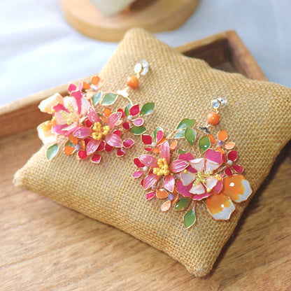 Samara handcrafted resin floral statement earrings vibrant pink orange white green gold on burlap cushion
