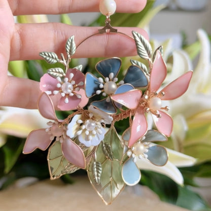 Close view of Shaylah pastel resin floral earrings showing green, pink and lavender petals with golden wire
