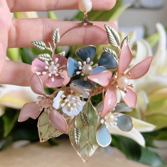 Close view of Shaylah pastel resin floral earrings showing green, pink and lavender petals with golden wire
