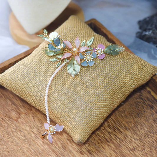 Shaylah pastel resin floral hand harness in green, pink and lavender laid on a jute cushion
