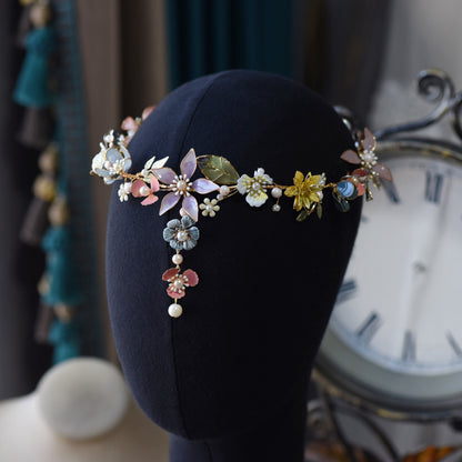 Shaylah pastel floral head harness displayed on a stand showing the golden vine and blooms
