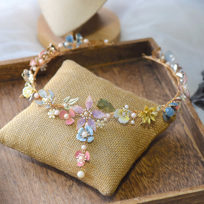 Shaylah pastel resin floral head harness in green, pink and lavender laid on a jute cushion
