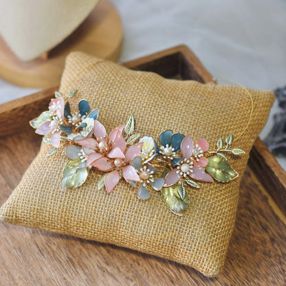 Shaylah pastel resin floral necklace in green, pink and lavender laid on a jute cushion
