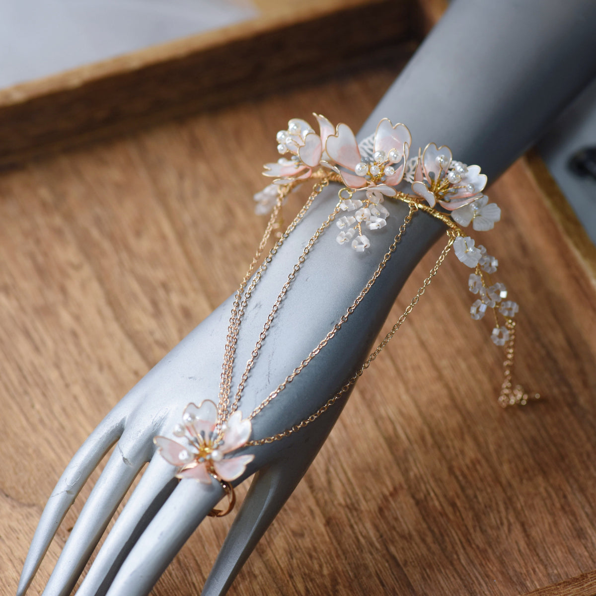 Sophia white and pearl floral haath phool on a display hand showing the wrist-to-finger vine
