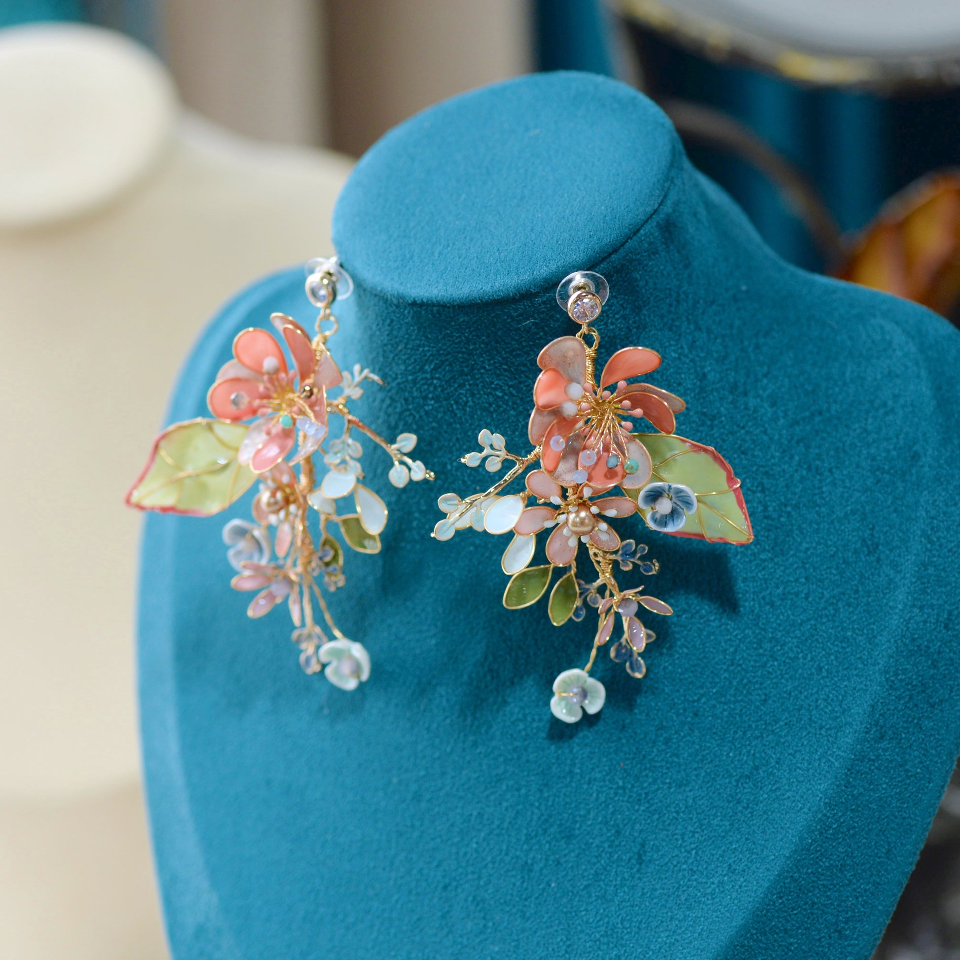 Trina coral resin floral earrings displayed on a stand showing the garden cluster design
