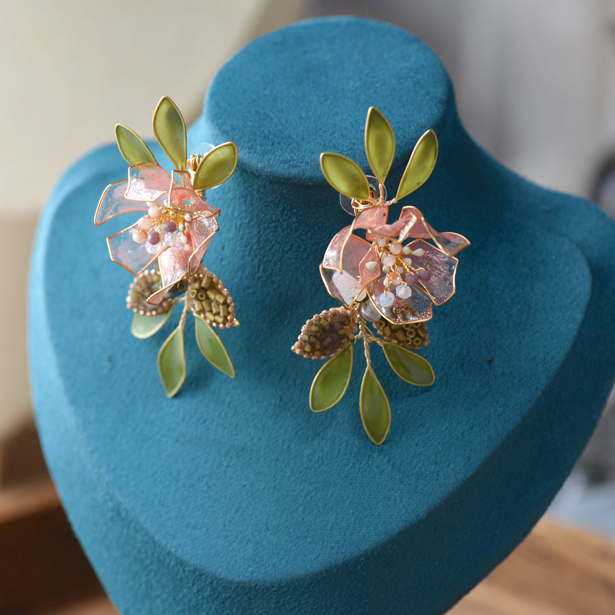 Valentina pink and green resin floral earrings displayed on bust
