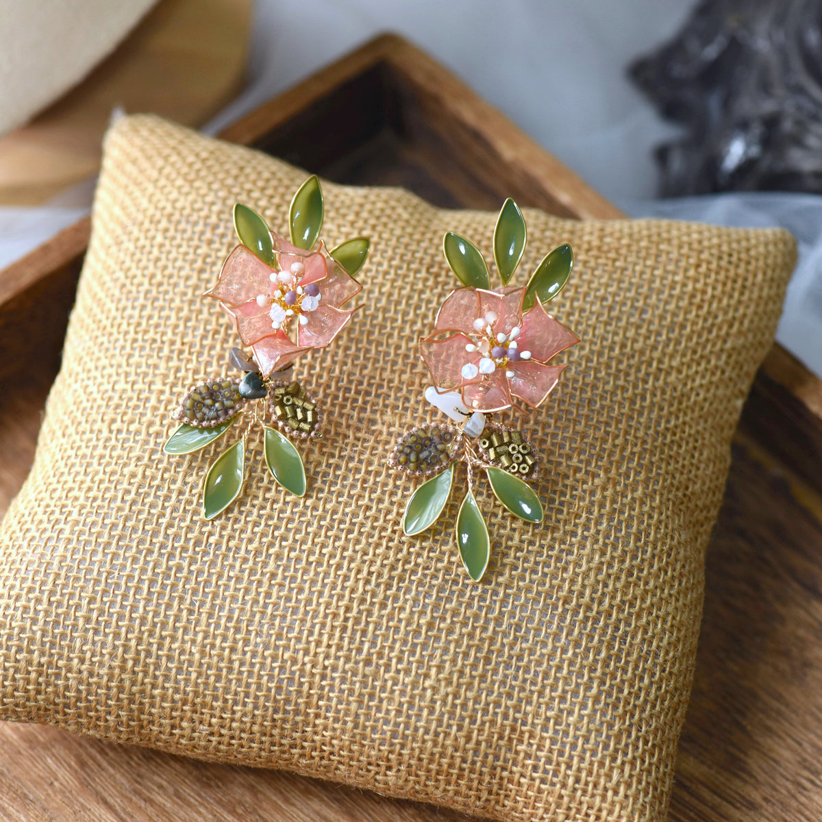 Valentina pink and green resin floral earrings on jute cushion
