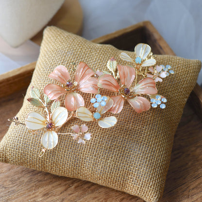 Vienna pastel orange and ivory resin floral hair accessory worn in a low bun
