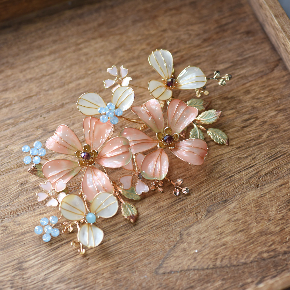Vienna pastel orange resin floral hair accessory detail showing veined petals and blue bead clusters