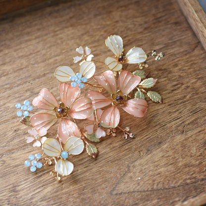 Vienna pastel orange resin floral hair accessory detail showing veined petals and blue bead clusters